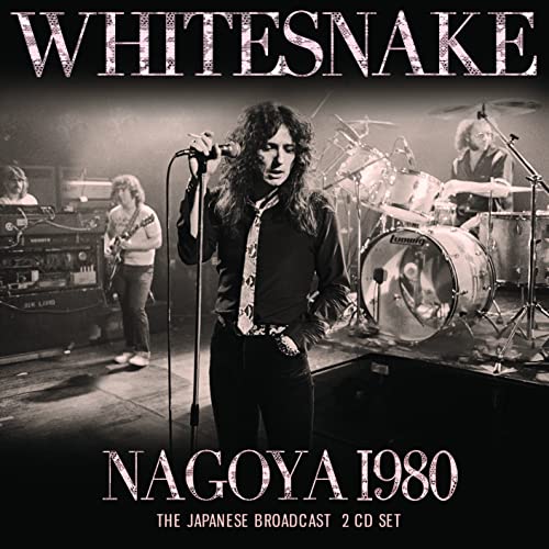 Whitesnake performing live on stage in 1980, with drums and musicians.