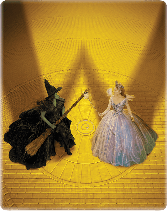 “Wicked” Steelbook cover featuring Elphaba and Glinda with wands on yellow brick road.