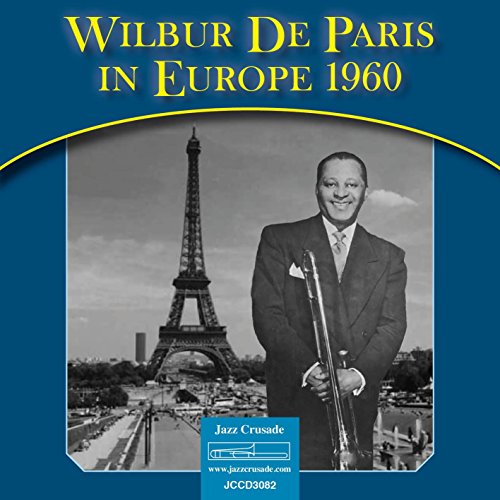 "CD cover with man in suit holding trumpet, Eiffel Tower in the background."