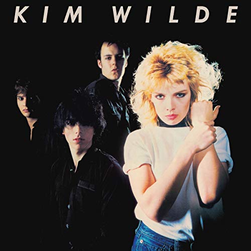 Kim Wilde and three band members in dark clothing against a black background.