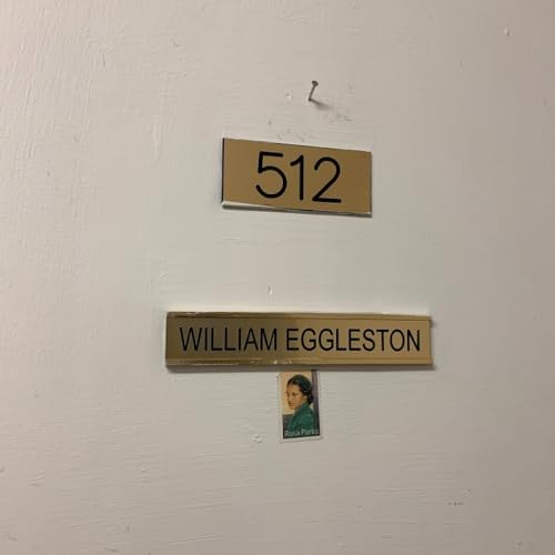 Brass plaques displaying “512” and “William Eggleston” with a small portrait.