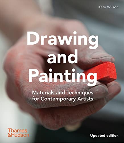 A hand covered in red chalk dust holds a piece of bright red pastel.