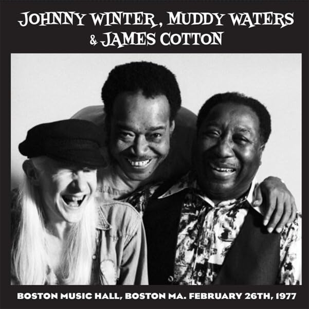 Johnny Winter, Muddy Waters, and James Cotton smiling in a black and white photo.