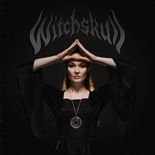 Witchskull album cover: woman with outstretched hands and ornate pendant.