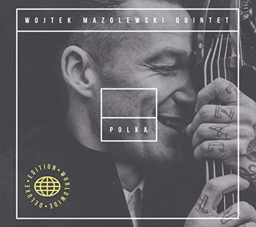 Black and white album cover featuring a bassist with hand tattoos.