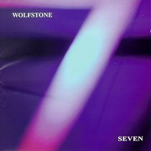 The image is an album cover for "Wolfstone - Seven [CD]" with EAN 48248119825. * The cover features a predominantly purple background. * A white, blurry diagonal line is visible, possibly representing a light beam or abstract design. * The band name "WOLFSTONE" is displayed in white text at the top-left corner. * The album title "SEVEN" is shown in white text at the bottom-right corner, accompanied by an Amazon logo. Alt