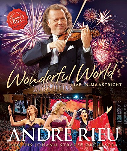 "Andre Rieu in a tuxedo holding a violin, with fireworks and three women singing."