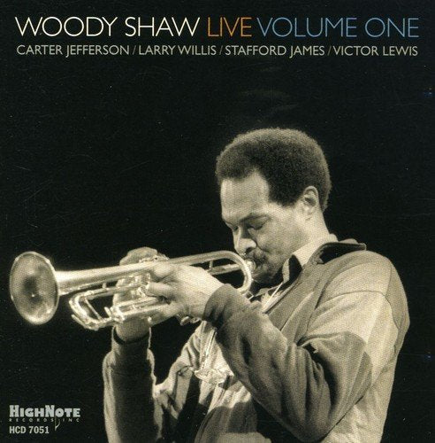 Album cover with black and white photo of man playing trumpet, on black background.