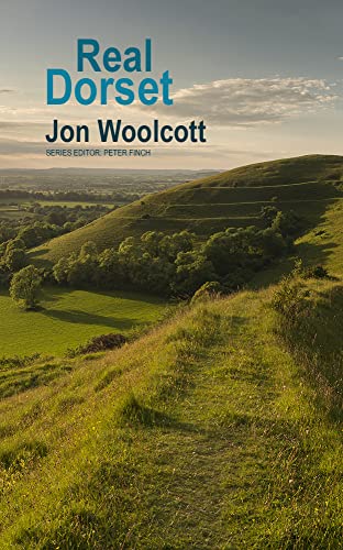 Book cover for Real Dorset by Jon Woolcott featuring a grassy hillside landscape.