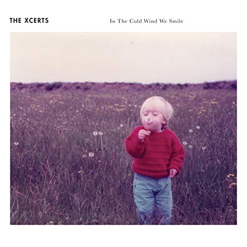 "Album cover with a child in a field, wearing red sweater and blue pants."