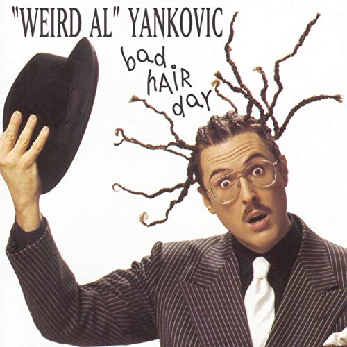 “Weird Al” Yankovic with wildly styled hair, holding a hat.
