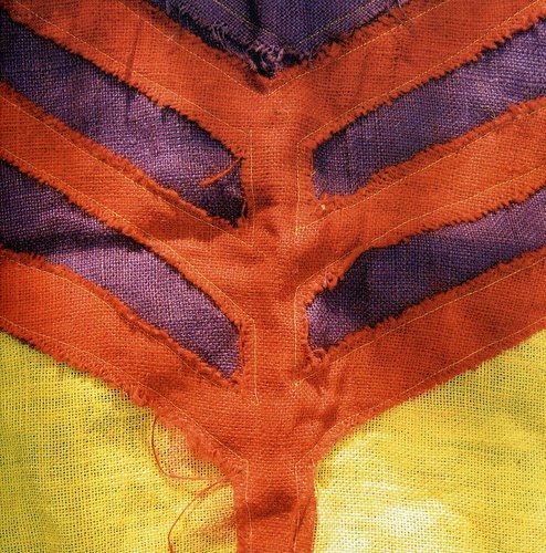 Close-up of abstract orange and purple fabric with yellow background.
