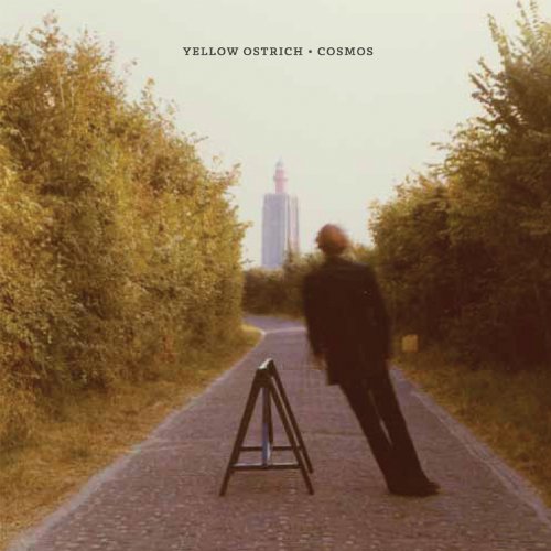 CD cover: man walking down a road towards a distant tower.