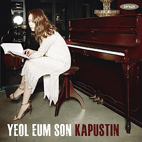 Pianist Yeol Eum Son seated at a grand piano, sheet music visible.