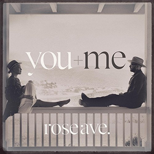 CD cover: two people sit on a railing with blurred background.