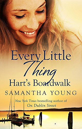Book cover with a smiling woman, boats, and sunset scene.