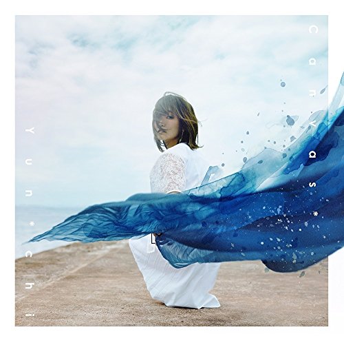 A woman in a white dress kneels on a pier with blue fabric flowing.