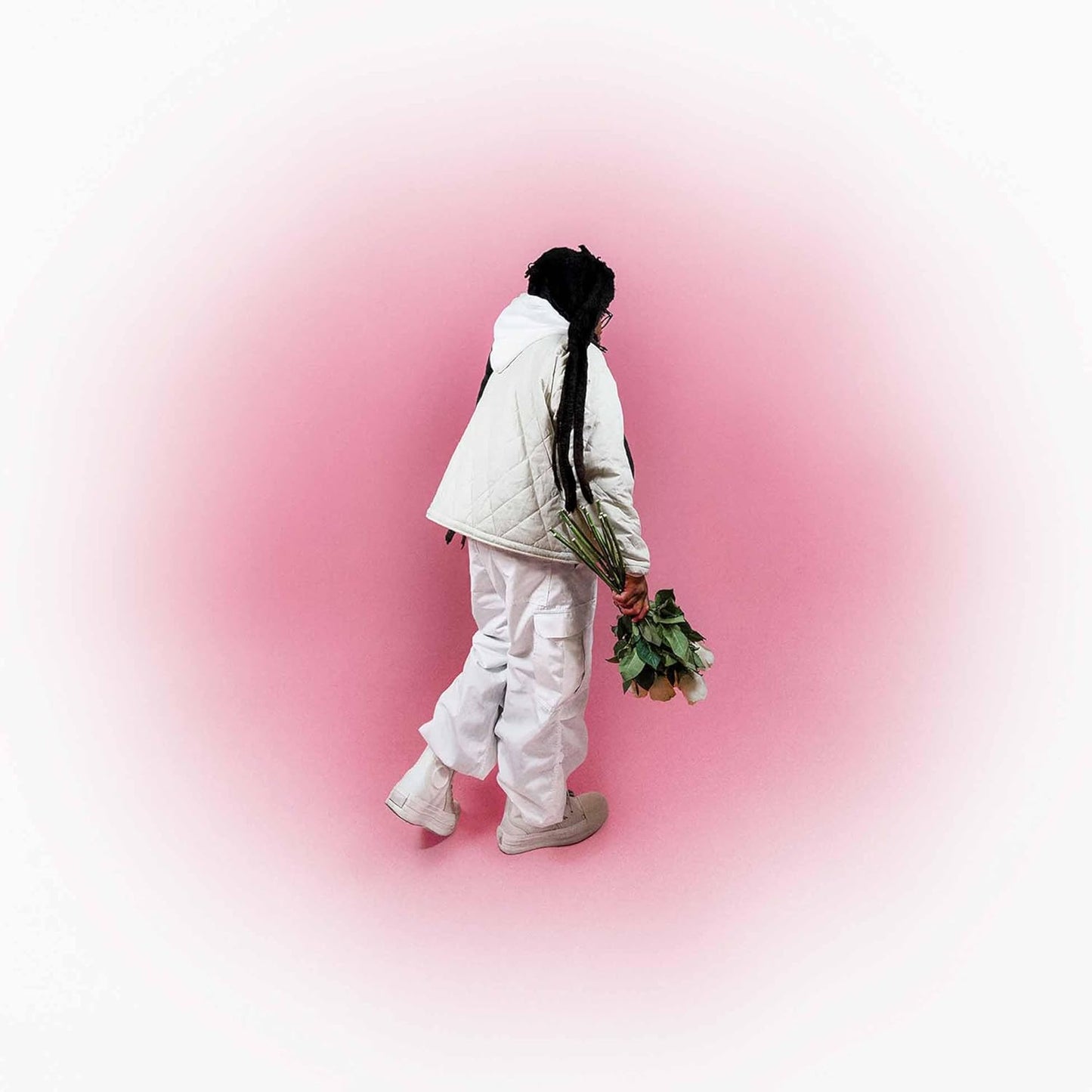 Person in white walking away holding green stems on pink background.