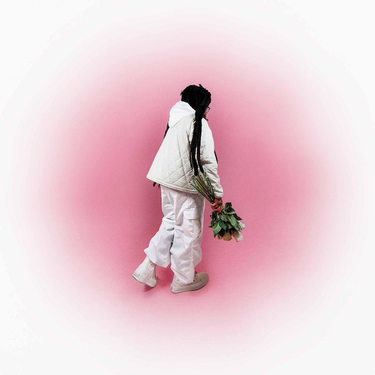Person in white walking away holding green stems on pink background.