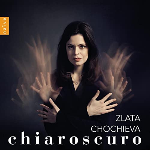 Portrait of pianist Zlata Chochieva with blurred, outstretched hands.