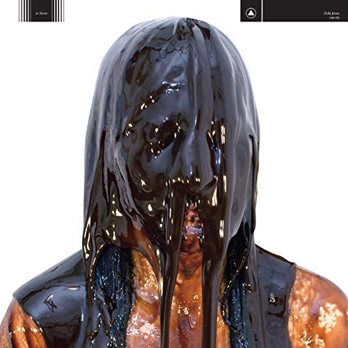 A person's head and shoulders covered in thick, glossy, dripping black liquid.