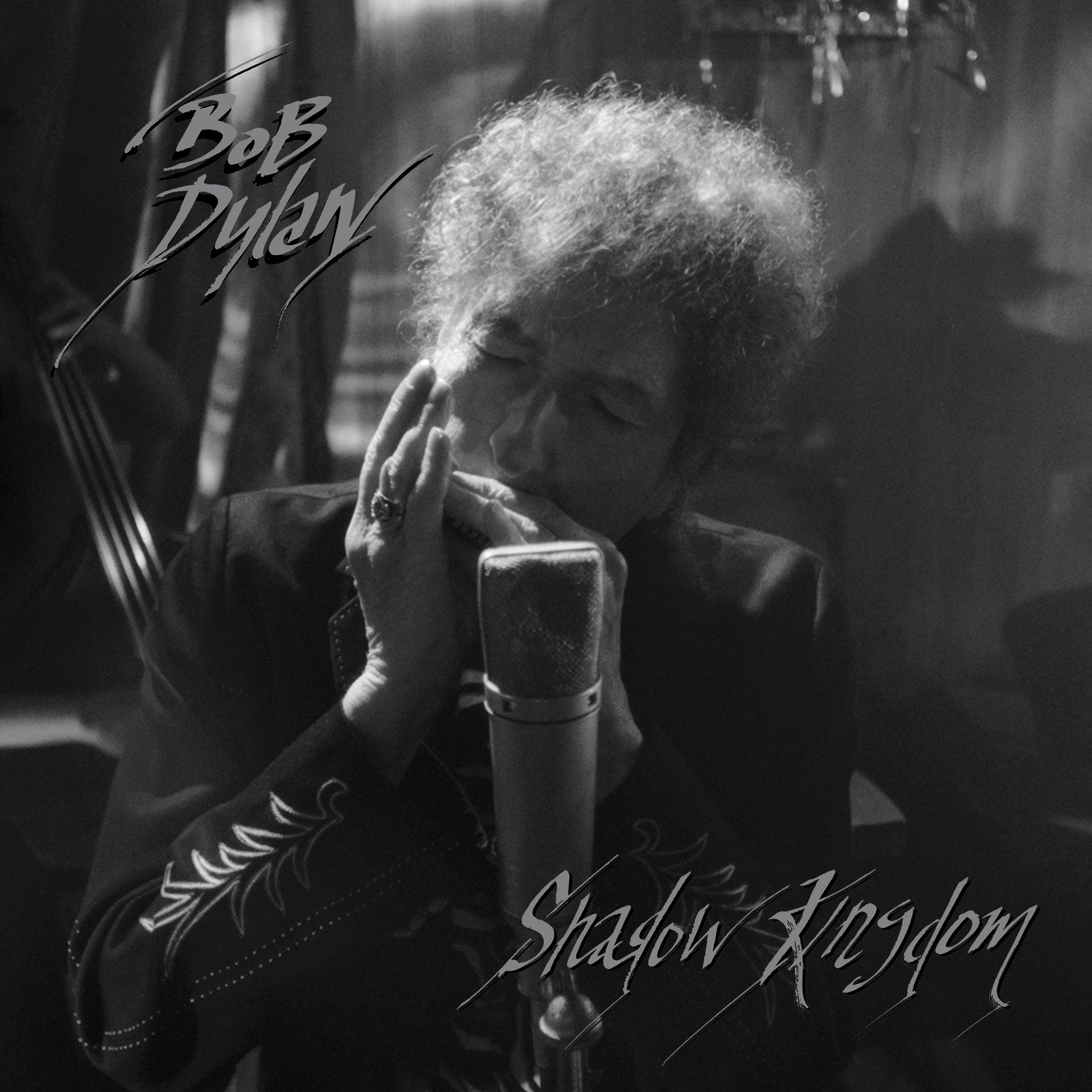 Black and white image of Bob Dylan singing into a microphone.