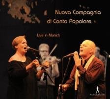 "CD cover featuring a man and woman singing into microphones on stage."