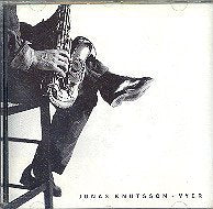 "Album cover featuring a man sitting on a stool, playing a saxophone."