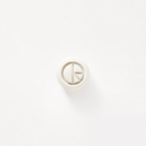 The image shows a white plastic object with a circular design on a white background. An appropriate alt text could be: "White plastic object with circular design on white background."