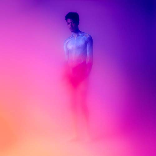 "Man with blue skin stands in a purple and pink haze."
