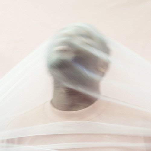 A blurred image of a man behind a white, translucent fabric.