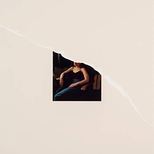 A beige album cover with a torn section revealing a woman sitting in a chair.