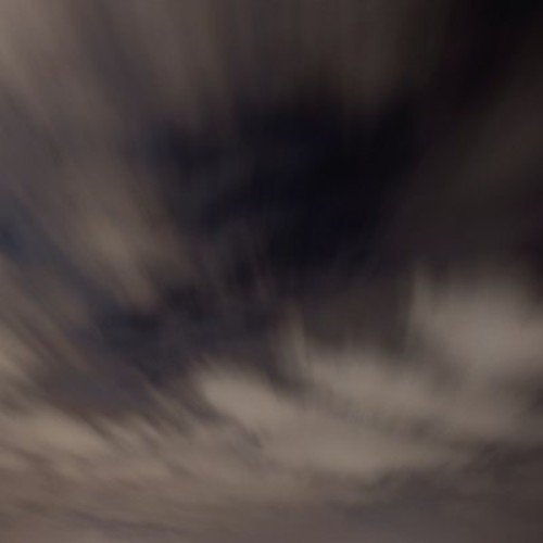 The image is too blurry to discern any specific details or objects. Alt text: "Blurry, dark image with white and gray swirls."