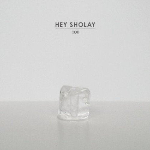 A melting ice cube on a grey surface, with "Hey Sholay ((O))" text above.