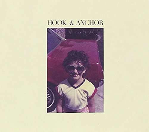 Album cover with a person wearing sunglasses standing in front of a red car.