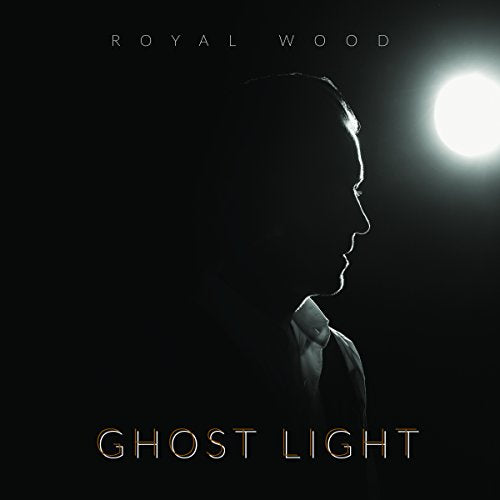 Album cover with a man's silhouette and bright light on a black background.