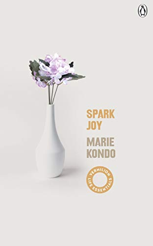 Book cover with white vase of purple flowers and text “Spark Joy.”