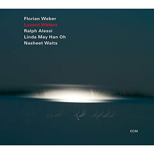 "Album cover with dark blue background, white glow, and artist names in white text."