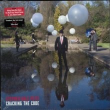 "Album cover with a suited man and floating balloons reflected in a pond."