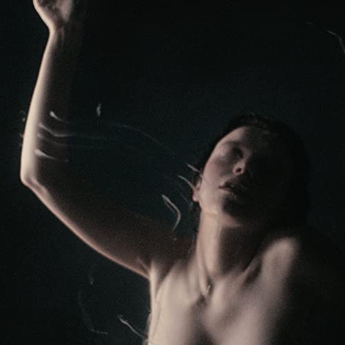 Dark album cover featuring a man submerged in water, arms raised.