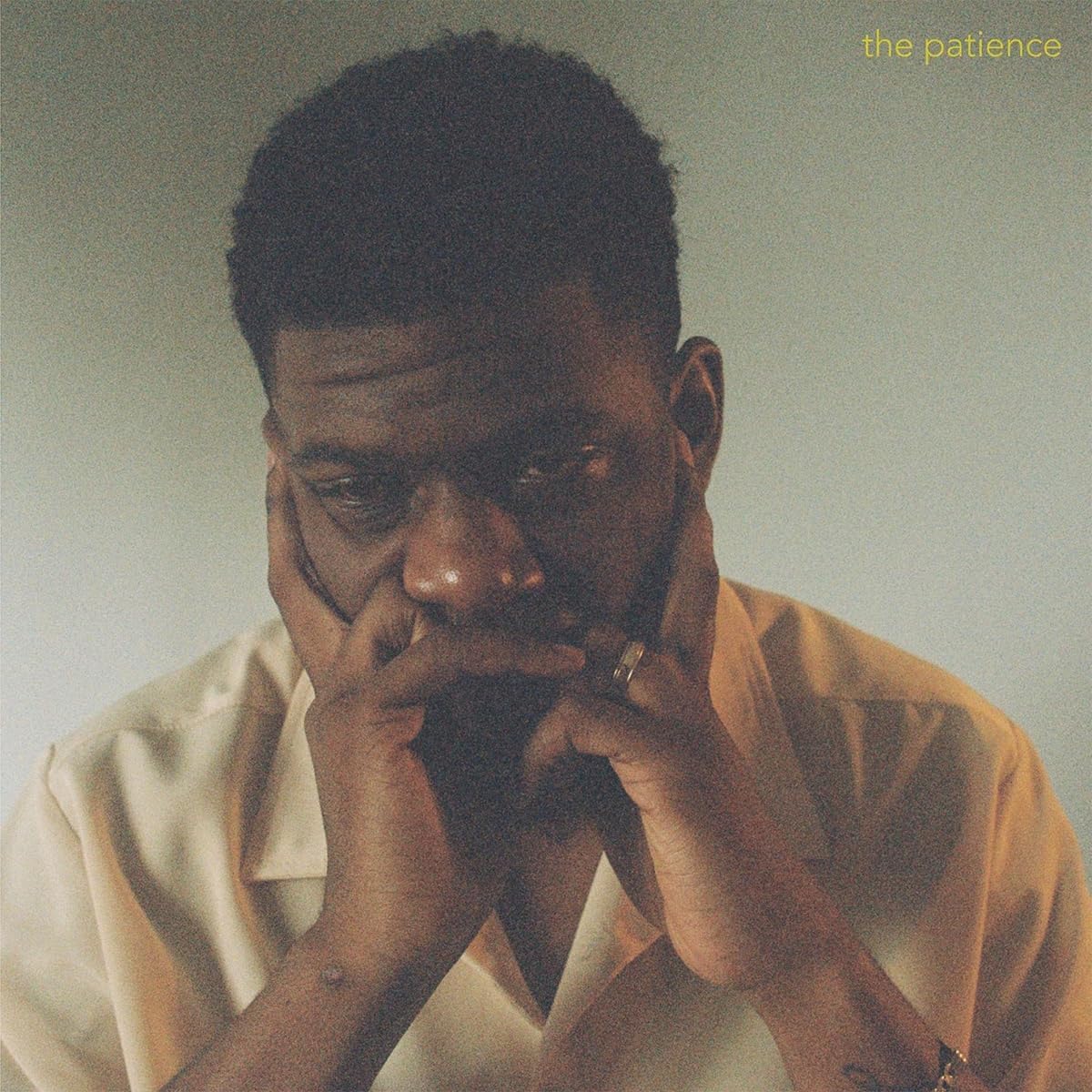 "Mick Jenkins album cover featuring a man resting his face on his hands."