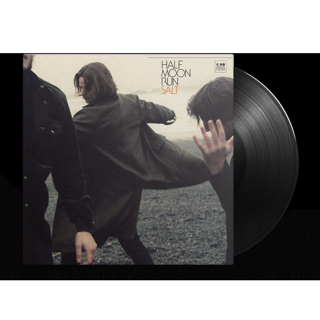 "Vinyl record cover with three men in dark clothing on a rocky surface."