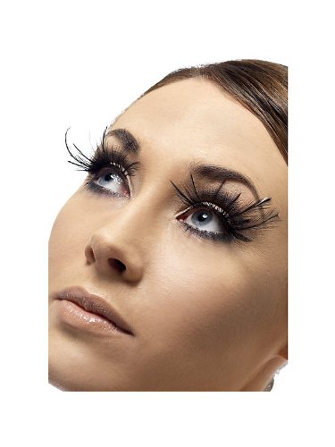 A woman's face with long, thick, black false eyelashes against a white background.