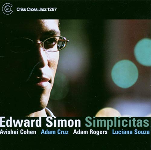 "Album cover with a man's face and blurry lights, featuring artist and title."