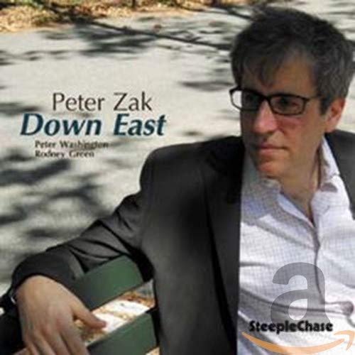 "Album cover with a man sitting on a bench, wearing a suit jacket."