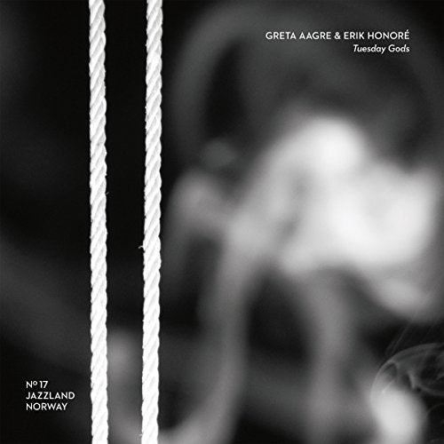 "Black and white album cover with blurred image and two white ropes on left."