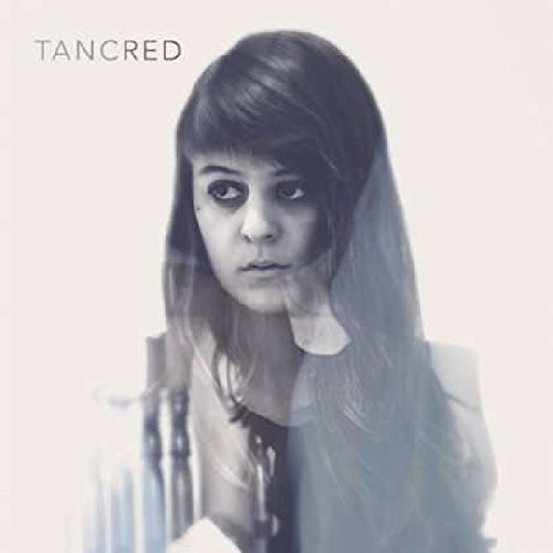 Album cover featuring a woman with dark hair, wearing a white top, against a white background.