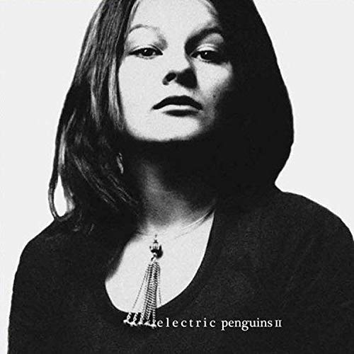 Black and white album cover with a woman wearing a dark top and tassel necklace.