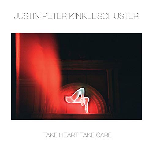 A vinyl record cover with a glowing heart in a dark arched doorway.