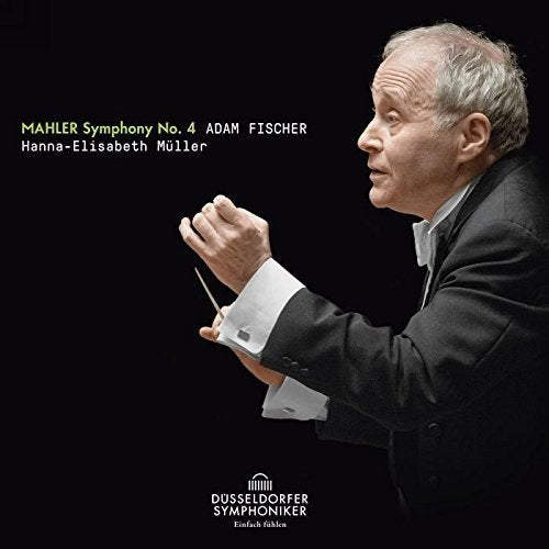 A conductor in a black suit holds a baton against a black background.